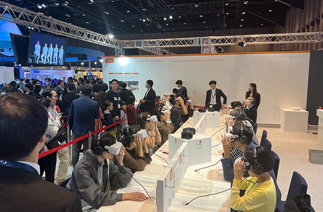 Canon EXPO 2023の会場で来場者が着席してHMDでVRを体験している様子